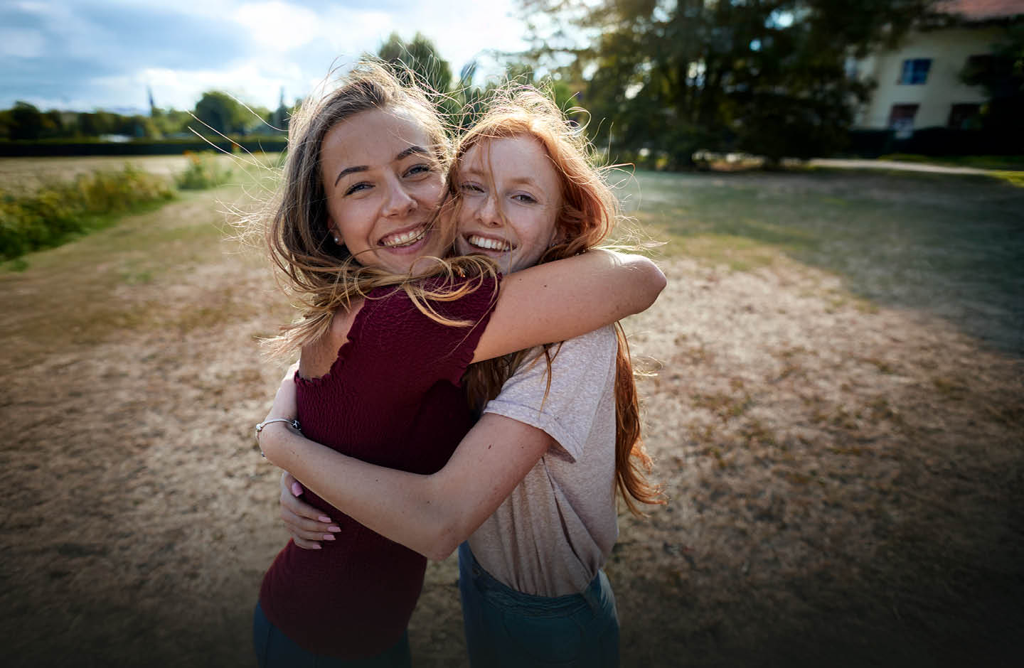 Zwei junge Frauen umarmen sich freundschaftlich